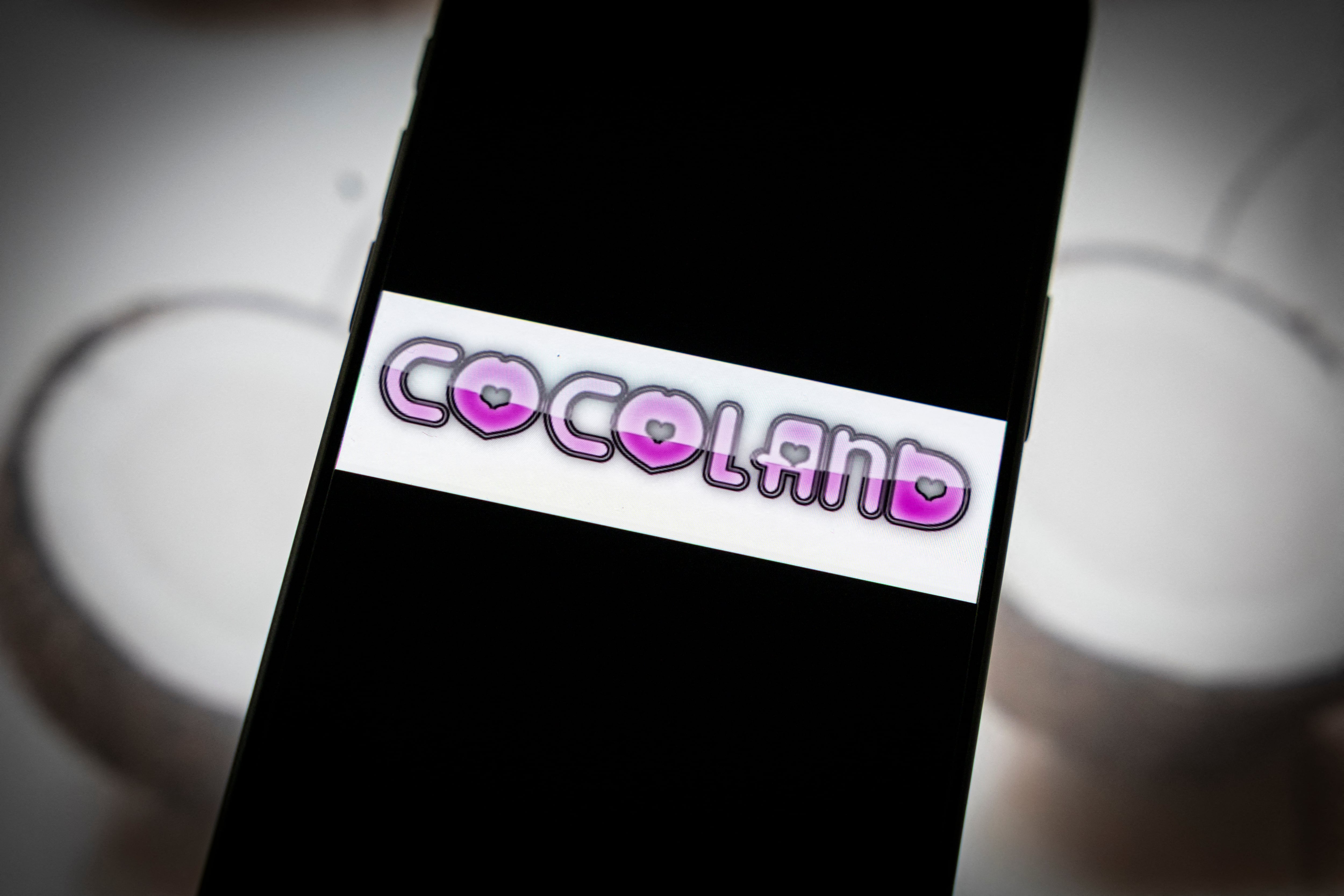 Esta fotografía muestra el logotipo del sitio web "Cocoland" en un teléfono inteligente en París el 28 de abril de 2026. Se ha abierto una investigación sobre la reaparición del sitio web Coco, ahora relanzado como Cocoland, a cargo de la unidad de delitos informáticos de la gendarmería francesa. El sitio, clausurado en 2024 por facilitar agresiones sexuales y ataques homófobos, reapareció con una nueva URL, provocando la indignación de grupos de protección infantil.