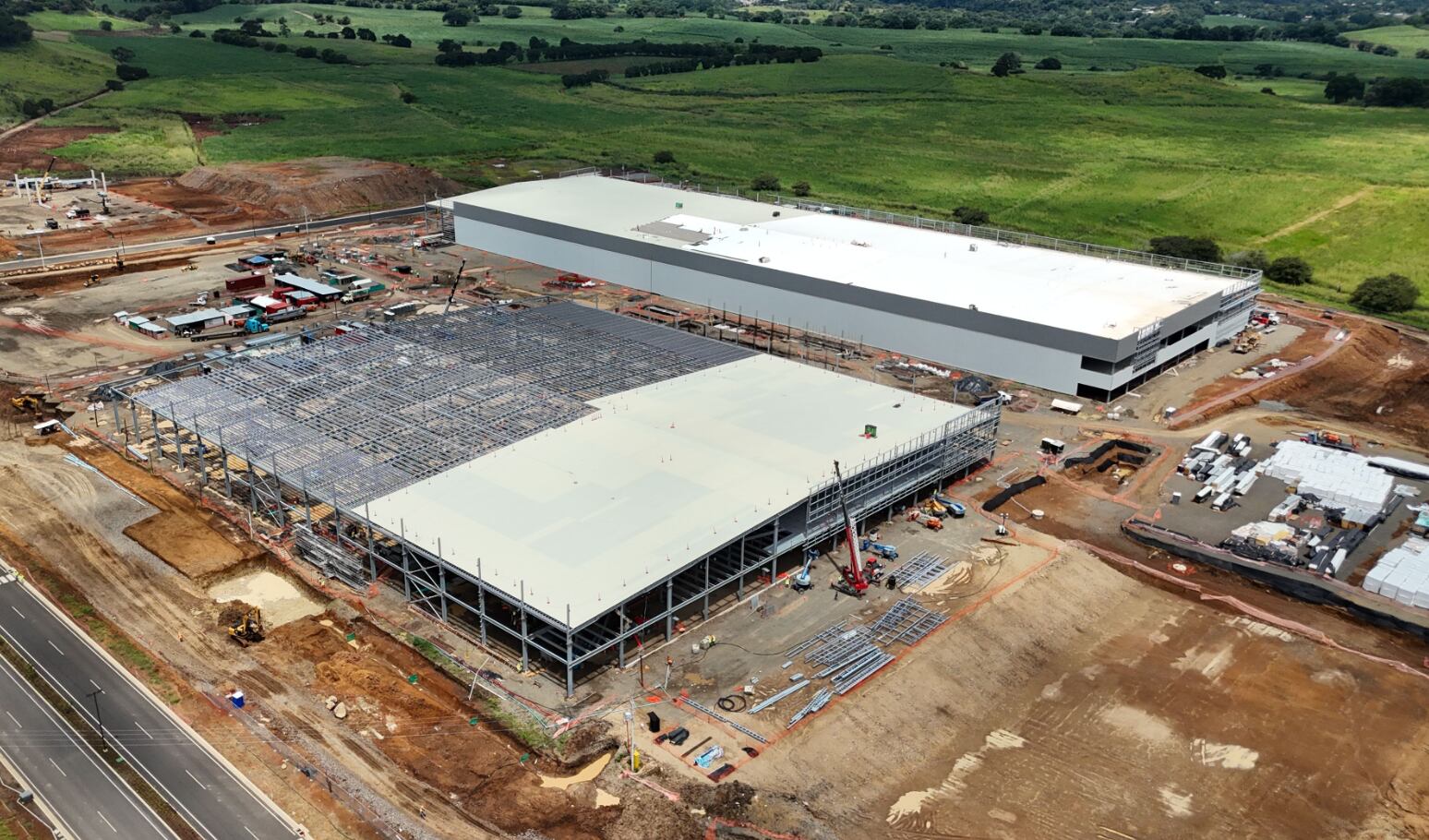 Vista aérea de la planta en construcción de Johnson & Johnson en Costa Rica, rodeada de áreas verdes y estructuras en desarrollo.