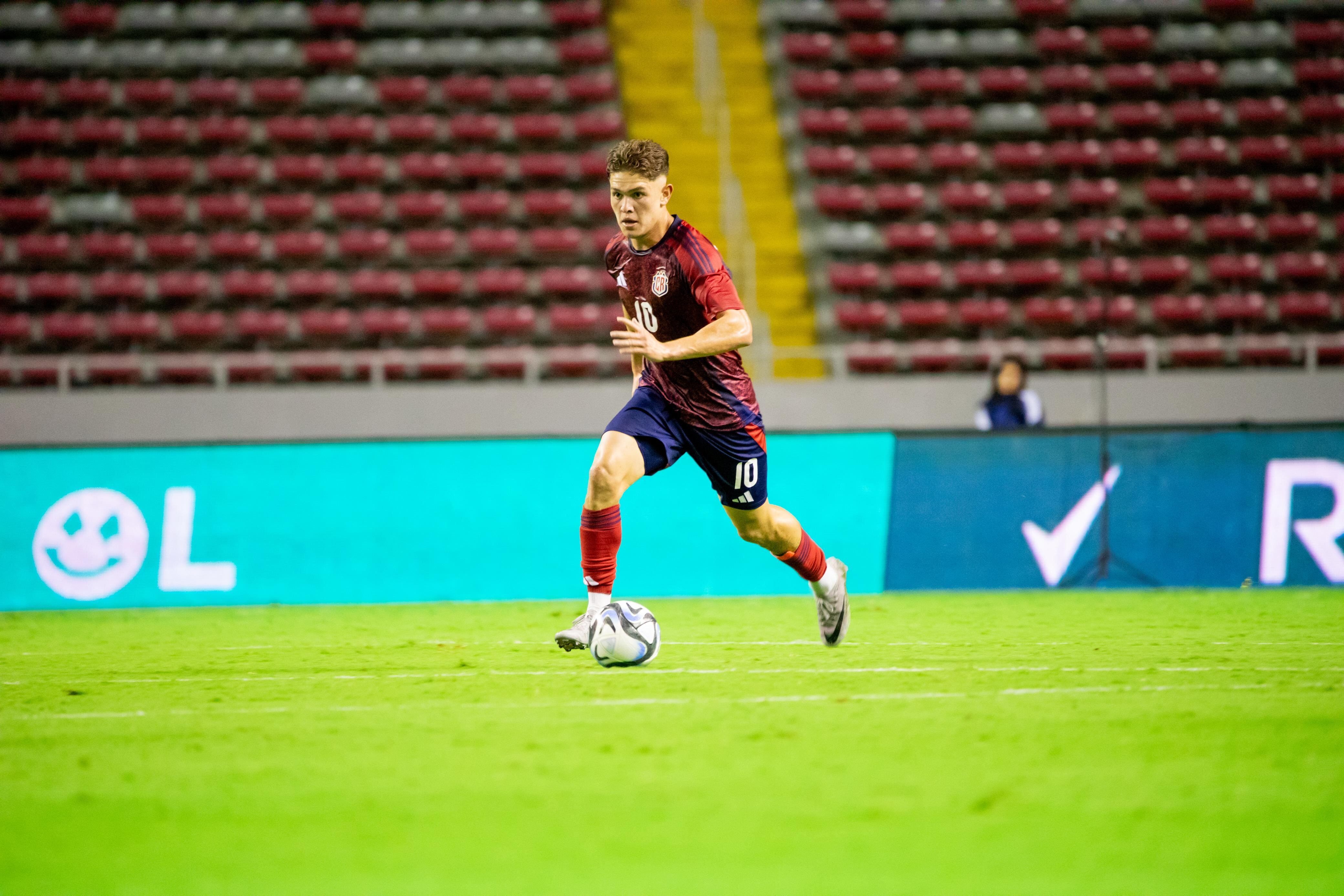 Brandon Aguilera le agradece a Gustavo Alfaro por señalar sus puntos de mejora. Foto: Fedefútbol.