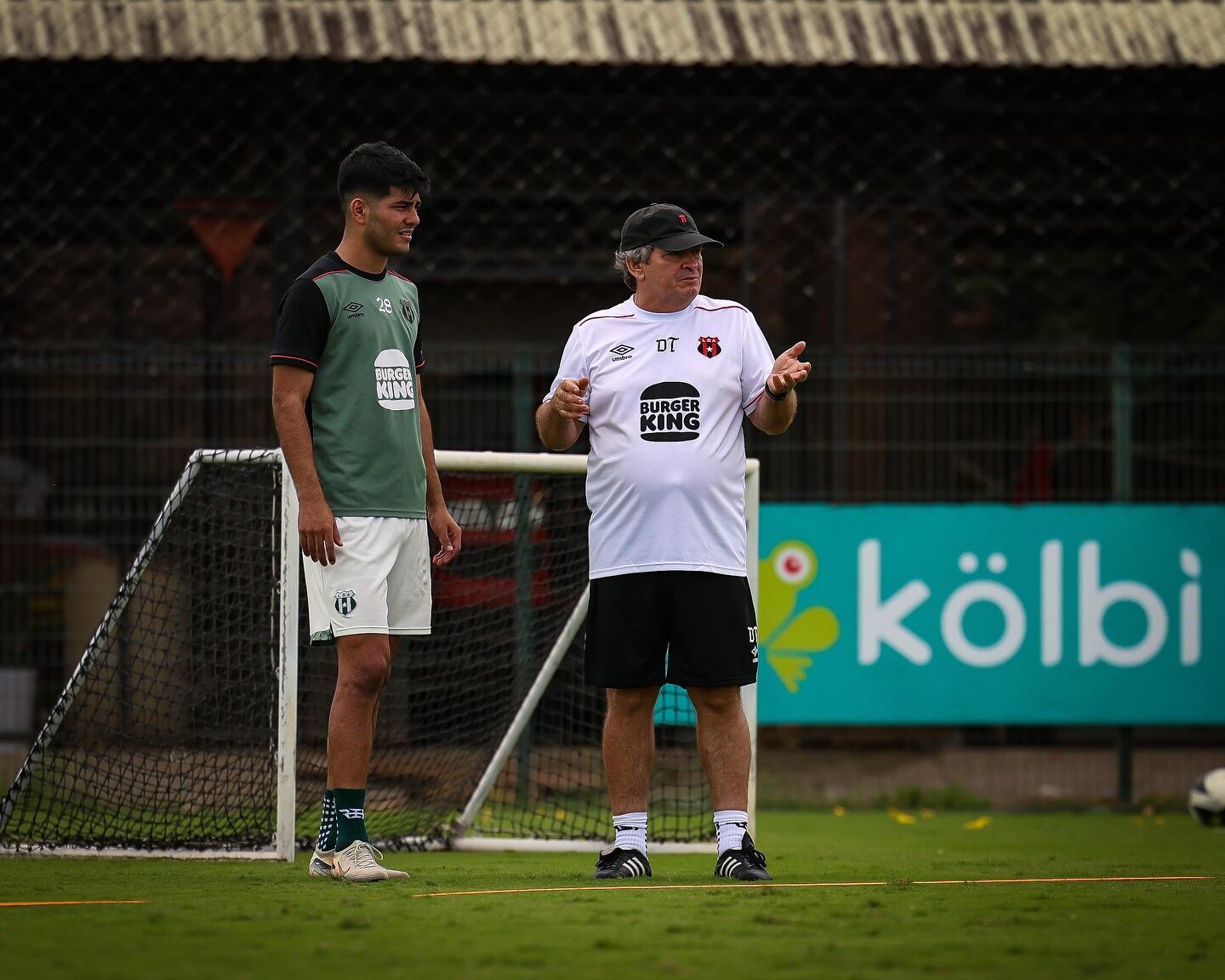 Joshua Navarro presta atención a las indicaciones de Óscar Ramírez en la práctica de Liga Deportiva Alajuelense.