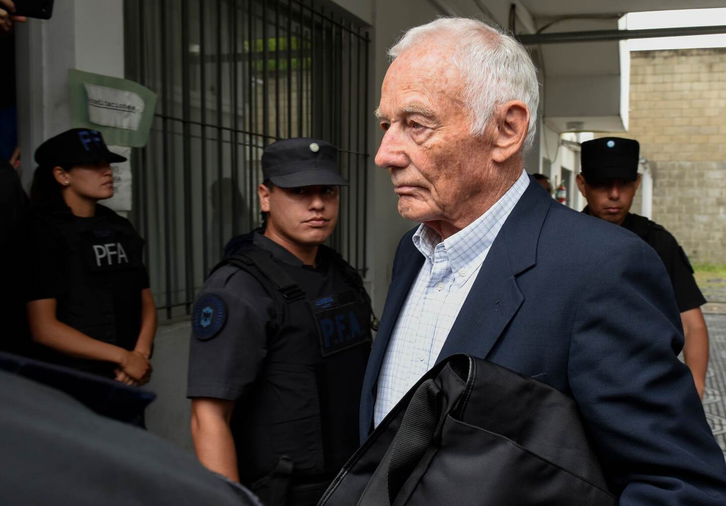Former Ford Motor Co. executive Pedro Muller leaves a courthouse after he was sentenced to 10 years for crimes against humanity committed against 24 Argentine union workers during the country's 1976-1983 military dictatorship, in Buenos Aires, Argentina, Tuesday, Dec. 11, 2018. The court said that Muller, then the factory manufacturing director, along with the security manager, targeted workers and were co-authors of human rights abuses including “illegal detentions” and “aggravated torments” when they gave information to security agents for their kidnapping and torture after the 1976 military coup. (AP Photo/Gustavo Garello)