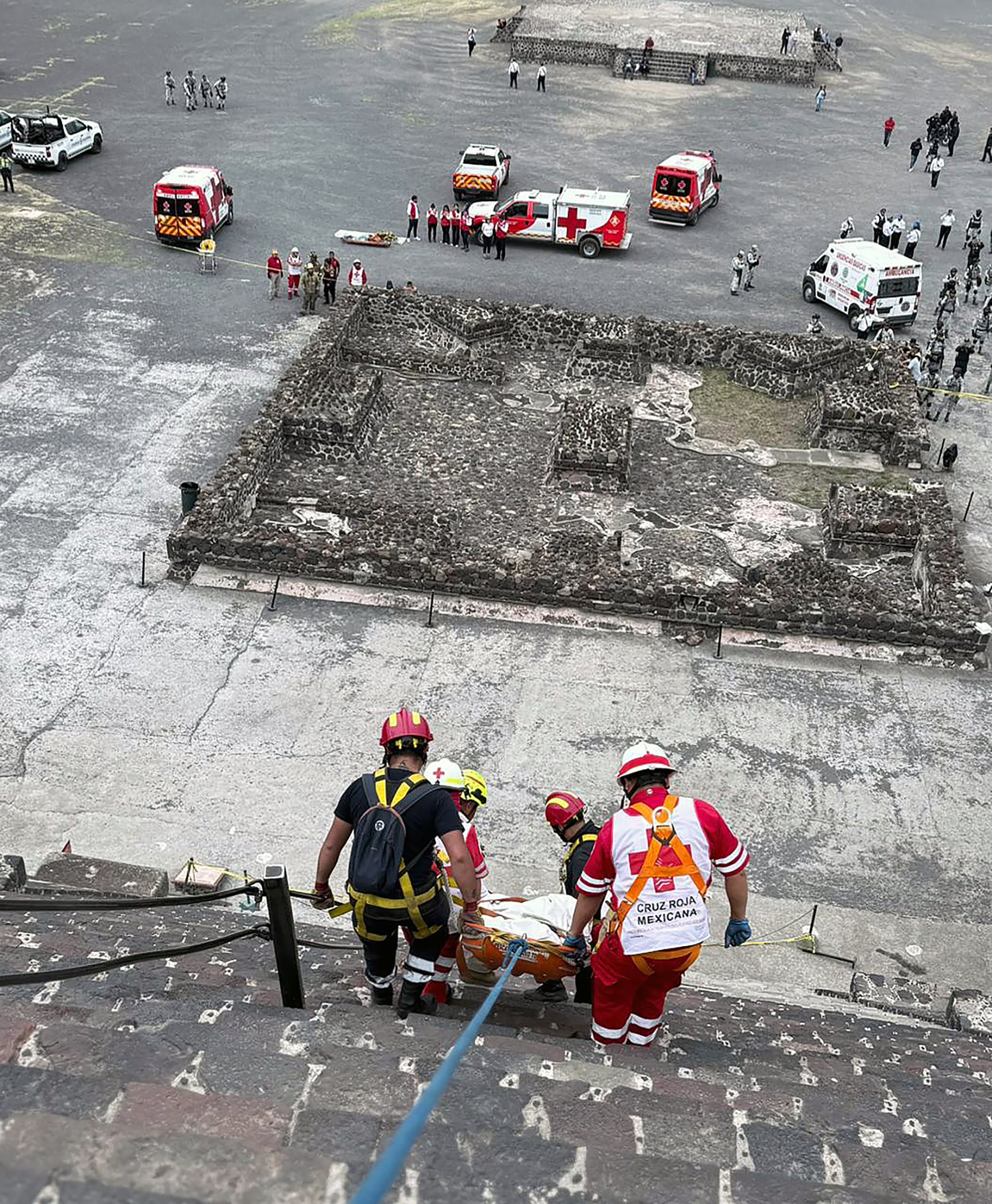Contenido gráfico / Esta fotografía distribuida por la Cruz Roja Mexicana muestra a expertos forenses y personal de la Cruz Roja transportando un cuerpo en la Pirámide de la Luna, en la zona arqueológica de Teotihuacán, tras un tiroteo ocurrido en Teotihuacán, Estado de México, el 20 de abril de 2026. Una mujer canadiense fue asesinada a tiros el 20 de abril en la zona arqueológica de las pirámides de Teotihuacán, en el centro de México, por un hombre que posteriormente se suicidó, según informaron las autoridades.