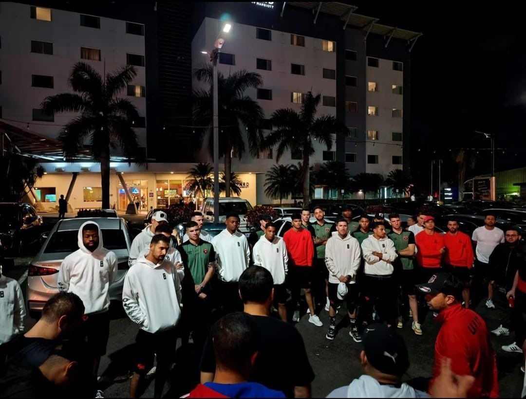 Los jugadores de Liga Deportiva Alajuelense escuchan con atención a varios integrantes de 'La Doce'.