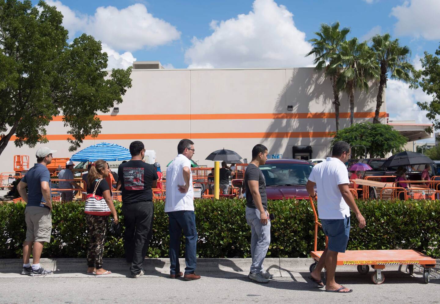 Decenas de personas esperan en las afueras de la tienda Home Depot en Miami, Florida, para comprar suministros.