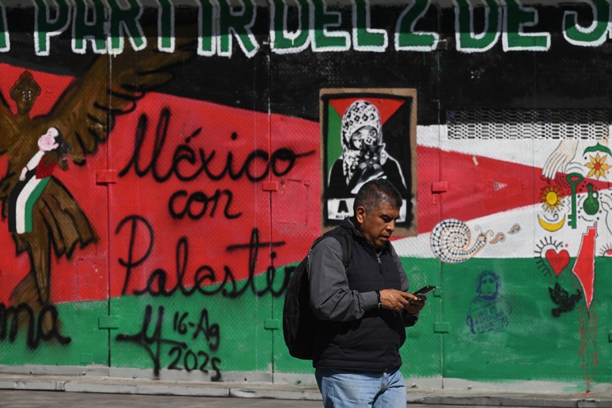 A man walks past a mural painted on a metal fence by pro-Palestinian supporters in the so-called Palestine Plaza in Mexico City on November 7, 2025. The United States and Israel on Friday accused Iran of plotting to assassinate Israel's ambassador to Mexico, in what would be the latest attempt to take the two countries' conflict to another region.