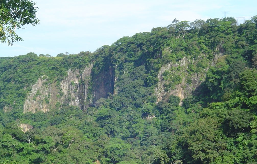 Vista panorámica del cañón del río Virilla en Costa Rica, con sus taludes cubiertos de vegetación y formaciones geológicas.