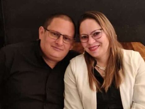 Una pareja, él a la izquierda de ella. Están abrazados.