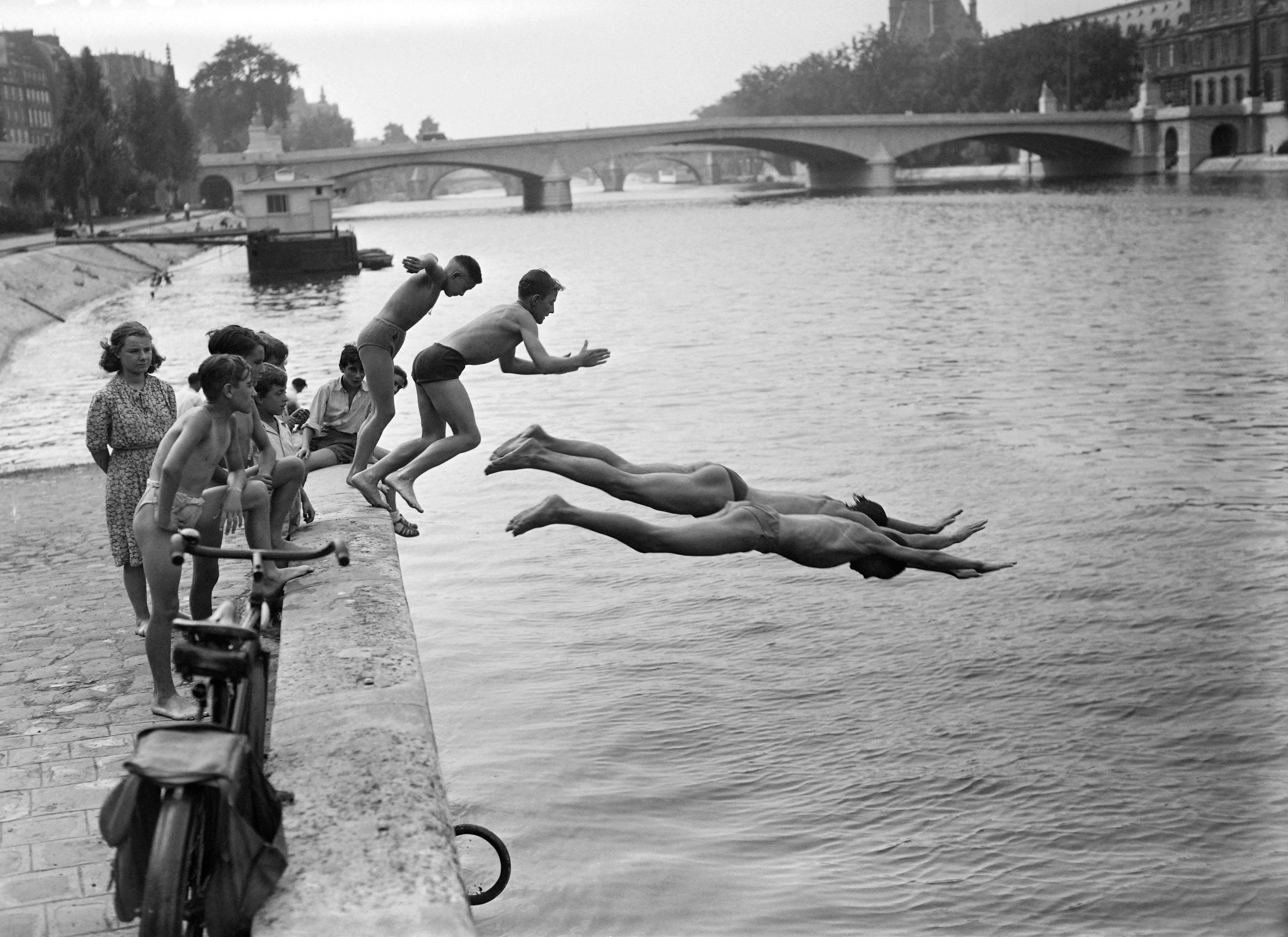 (ARCHIVO) Personas se zambullen en el río Sena cerca del puente du Carrousel, en julio de 1949 en París, durante una ola de calor en la capital. El río Sena reabrió a los bañistas la mañana del 5 de julio de 2025 en París, permitiendo a las personas darse un chapuzón en esta emblemática vía fluvial de la capital francesa por primera vez desde 1923.
(Foto: AFP)