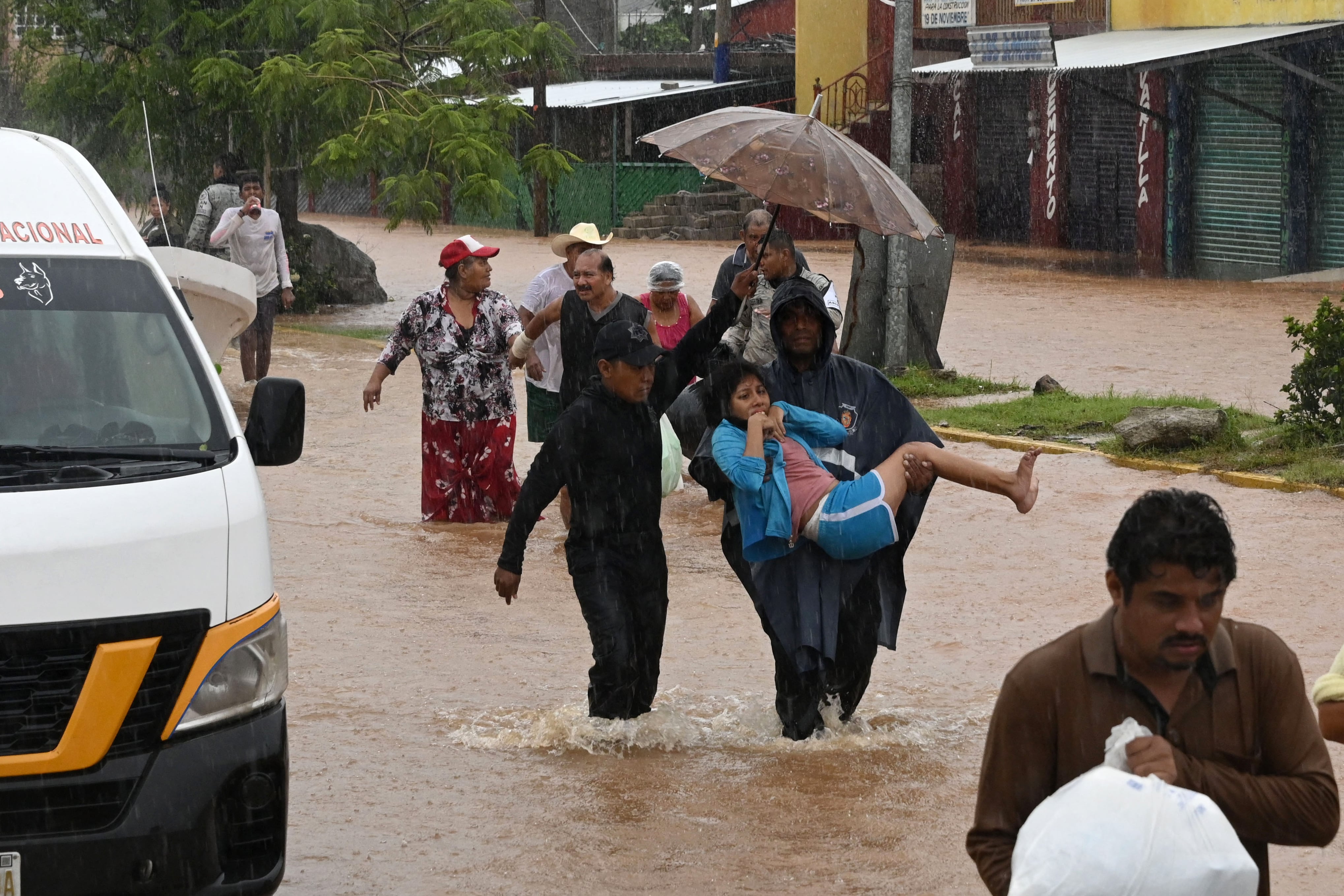 La gente camina por una calle inundada tras el paso del huracán John por Acapulco, México.
