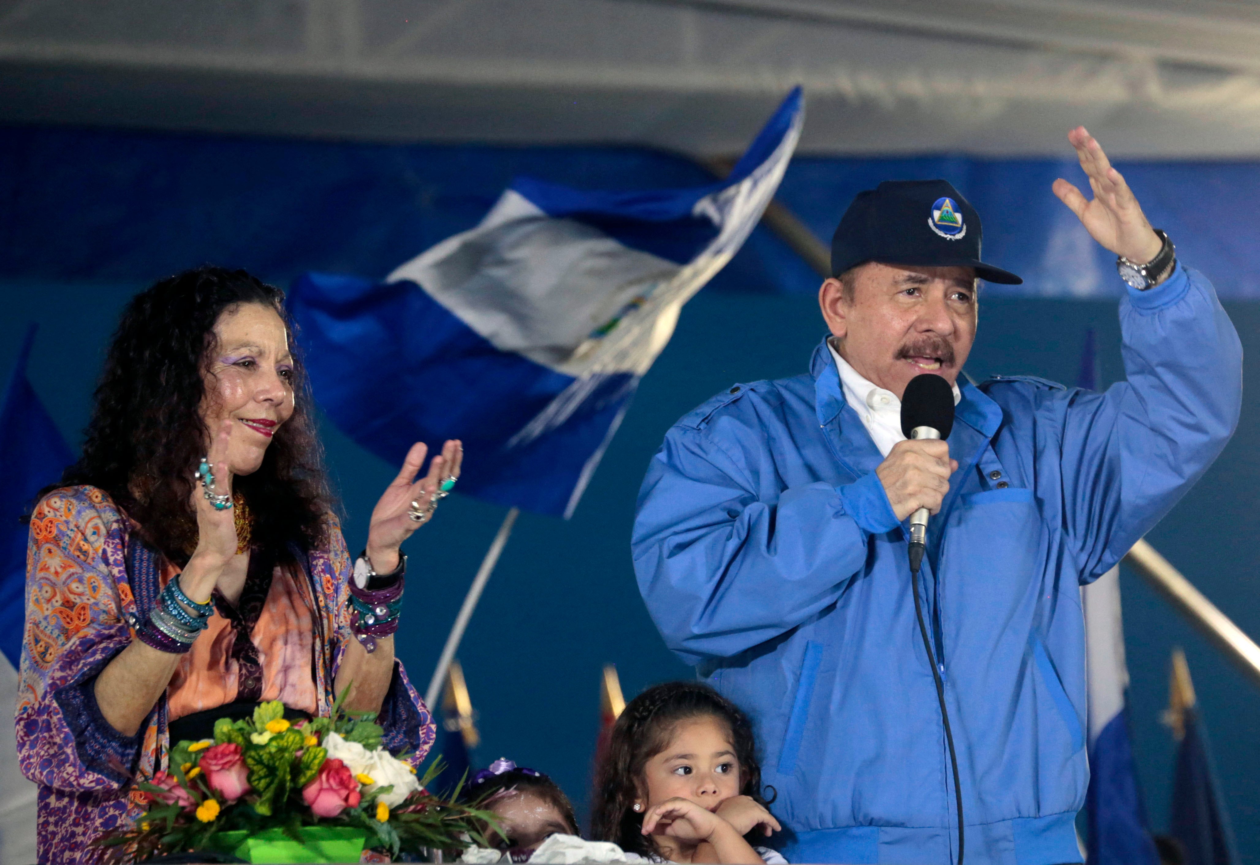 El presidente de Nicaragua, Daniel Ortega, y su esposa, la vicepresidenta Rosario Murillo, levantan el puño durante la conmemoración del 51º aniversario de la campaña guerrillera de Pancasan en Managua, el 29 de agosto de 2018.
La esposa del presidente nicaragüense Daniel Ortega, la "copresidenta" Rosario Murillo, asumirá el mando del Ejército en virtud de una reforma legal aprobada el 25 de marzo de 2025, en primera instancia, por el Congreso. (Foto de INTI OCON / AFP)