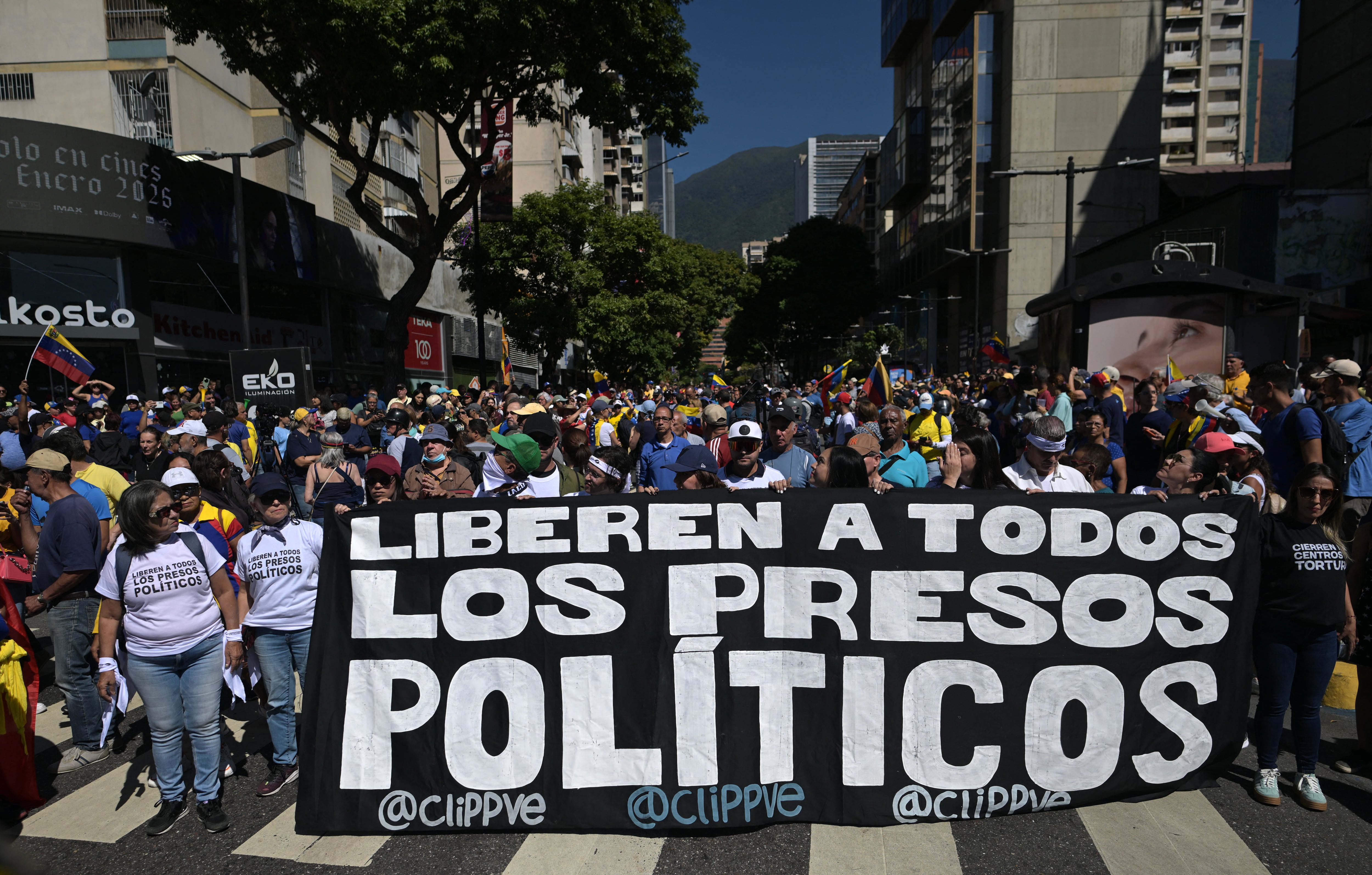 Manifestantes sostienen una pancarta en la que exigen la liberación de todos los presos políticos durante una protesta convocada por la oposición en vísperas de la toma de posesión presidencial, en Caracas, el 9 de enero de 2025.