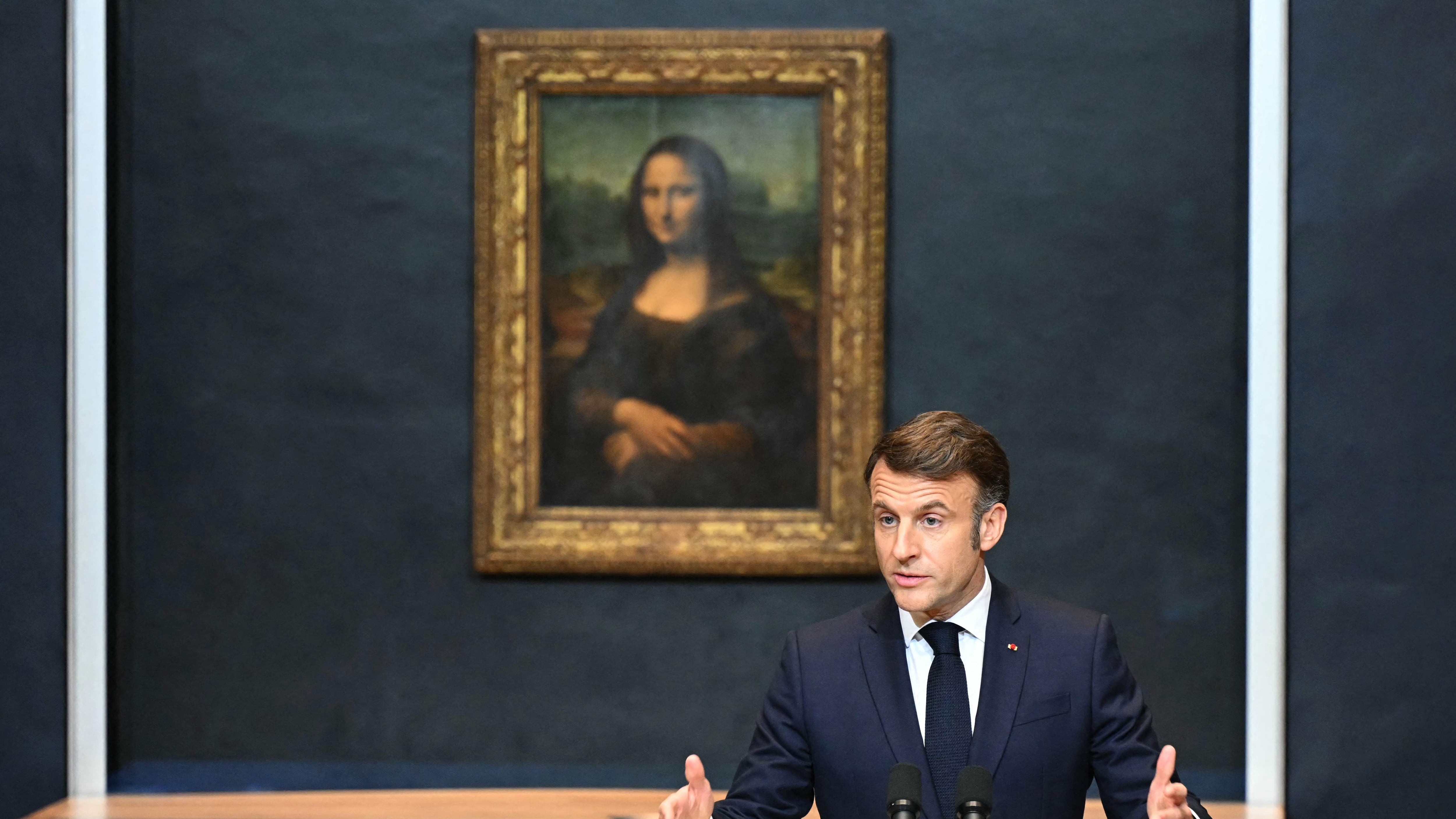 Emmanuel Macron dando un discurso en el Museo de Louvre con la Mona Lisa de fondo