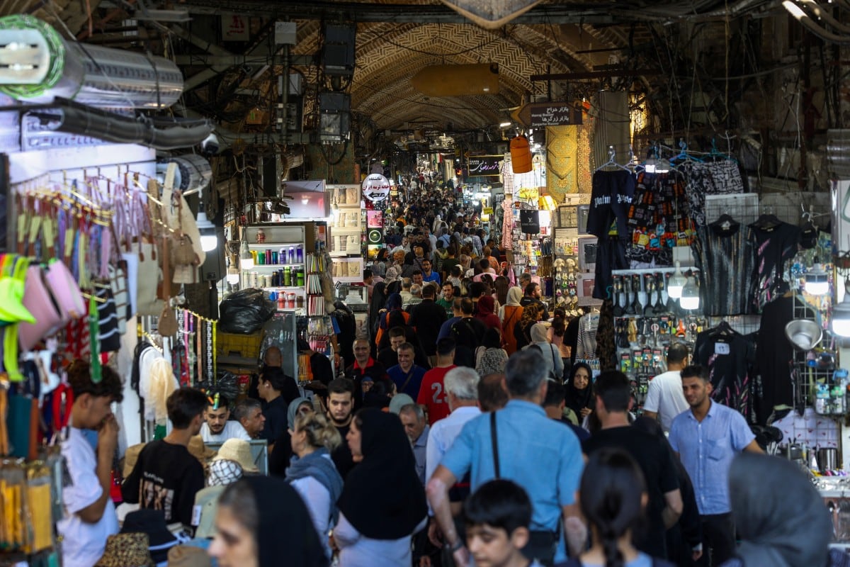 (ARCHIVO) Personas pasan frente a tiendas y observan productos en el Gran Bazar de Teherán, el 24 de agosto de 2026.