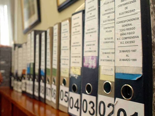 26/5/06.A partir de una investigacion realizada por La Nacion,en el que realaciona al Expresidente Miguel Angel Rodriguez,con problemas con los reaseguros depositados por el INS a empresas del eexpresidente,el jerarca de la entidad aseguradora Guillermo Constenla se dio a la tarea de pedir todos los expedientes y ser trasladados a su despacho.Foto de Jorge Castillo.3:30pm.Carlos Rojas Ortiz ayudo a acomodar los ampos con dicha informacion.