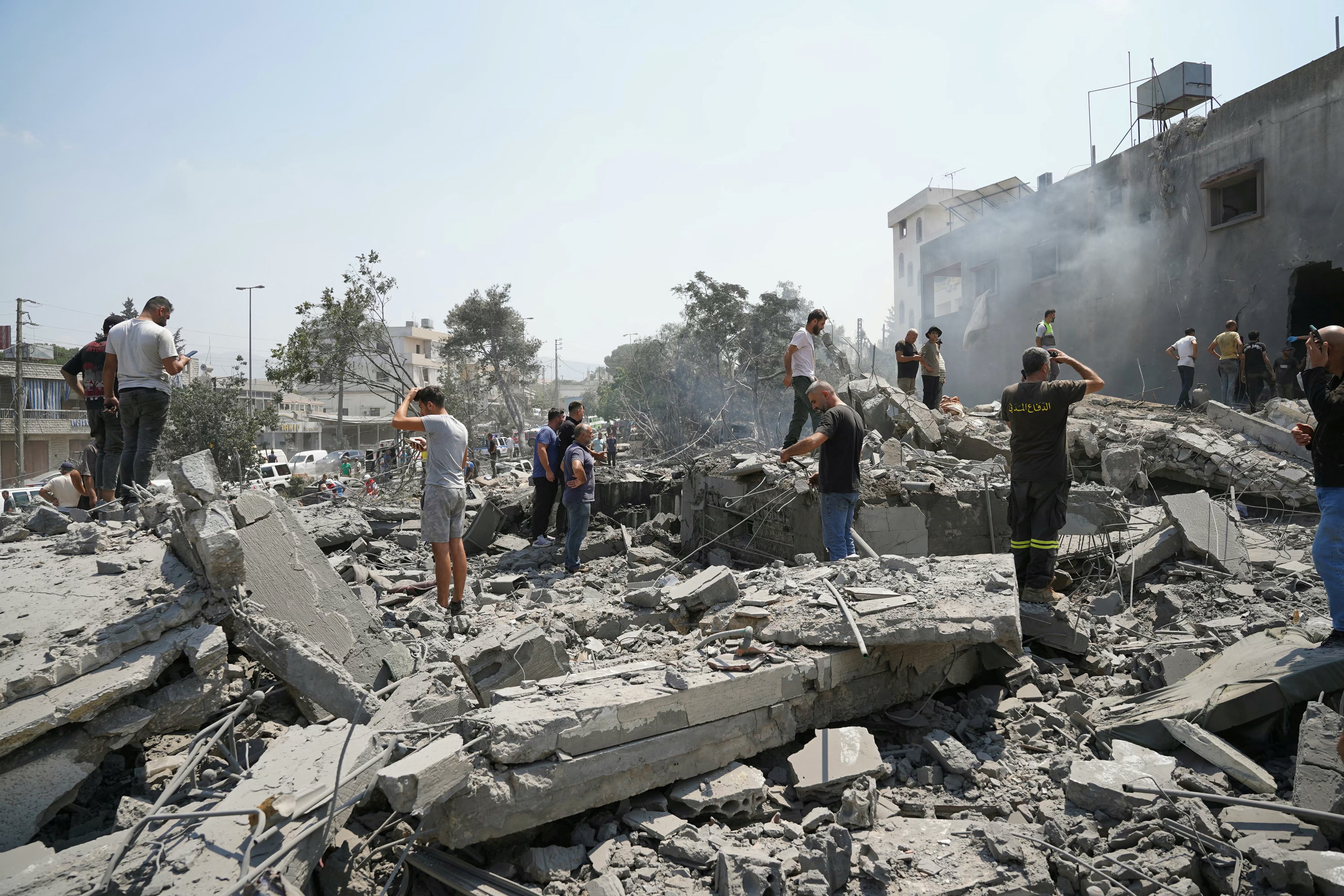 Socorristas y residentes acuden al sitio de un bombardeo israelí en la localidad de Deir al-Zahrani, en el sur de Líbano, este 15 de agosto.