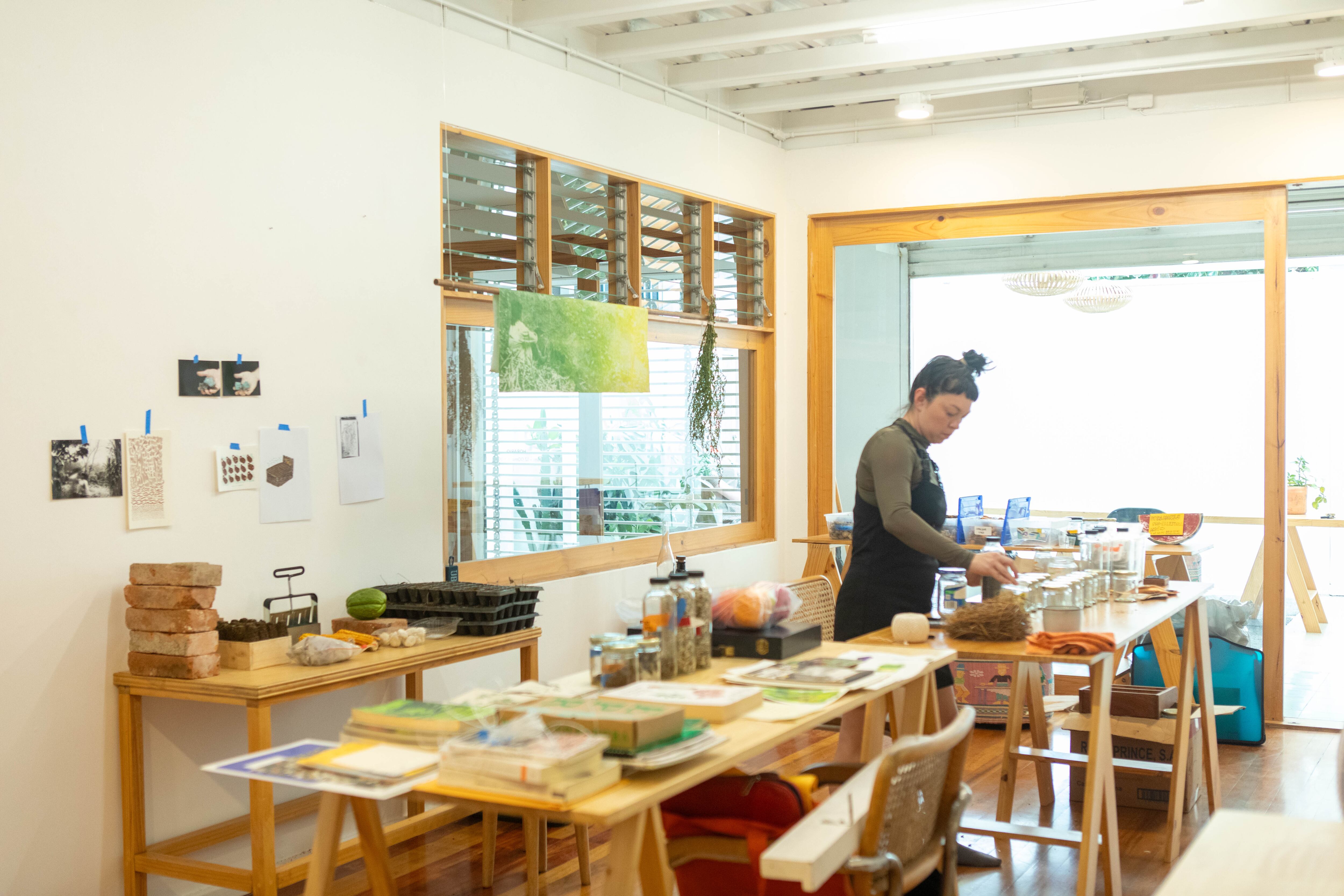 La artista Mariela Richmond durante su residencia en Satisfactory, en barrio Escalante, San José. Exhibe libros, semillas, obra gráfica y más elementos relacionados con su investigación.