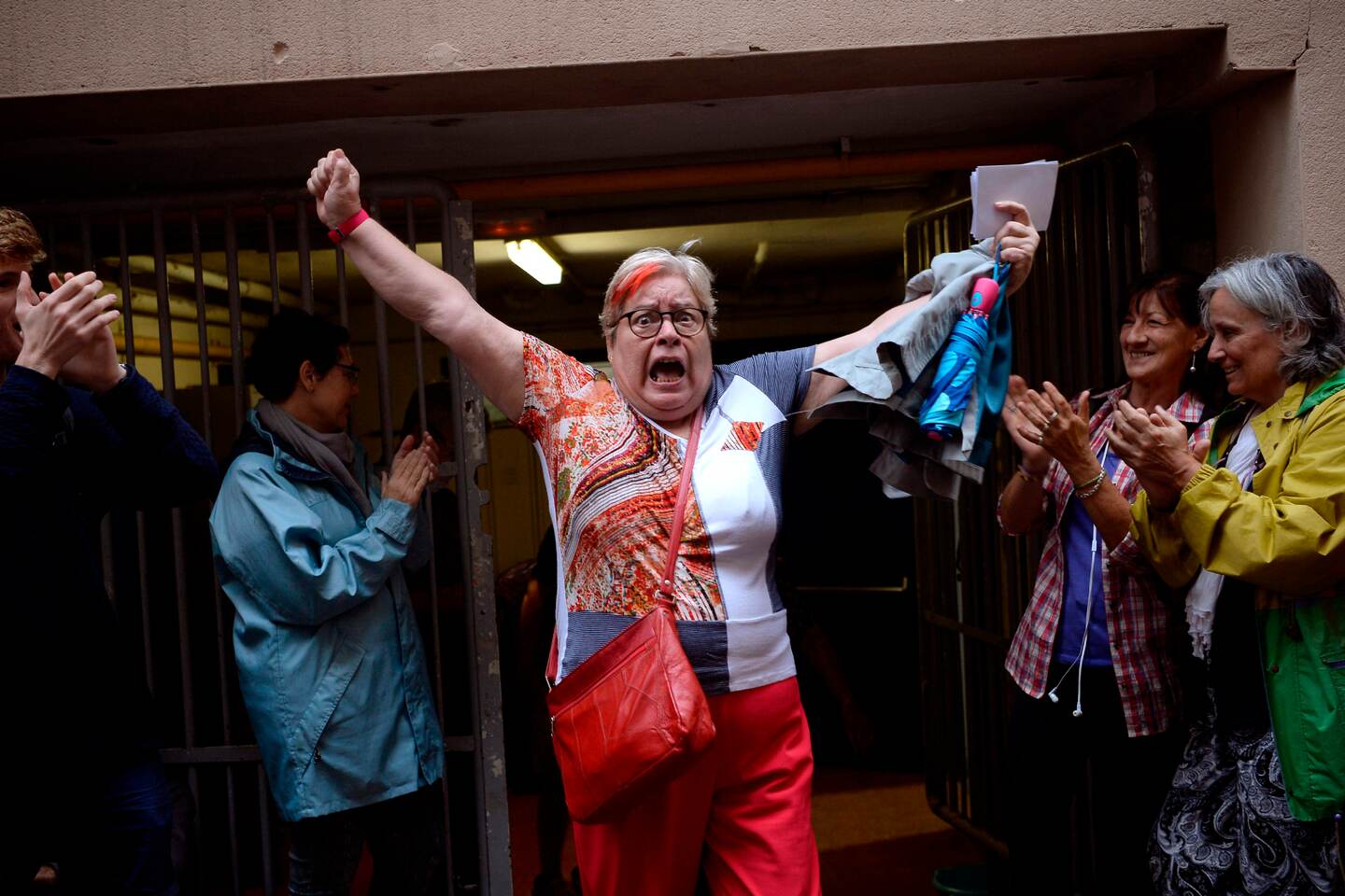 (FILES) In this file photo taken on October 01, 2017 a woman celebrates outside a polling station after casting her vote in Barcelona, in a referendum on independence for Catalonia banned by Madrid. - The trial of 12 Catalan separatist leaders involved in a bid to secede from Spain that plunged the country into crisis starts on February 12, 2019 under intense scrutiny and controversy. Expected to last three months, the trial is due to be broadcast live on television from the Supreme Court in Madrid where 600 journalists from 150 domestic and foreign media are accredited. (Photo by Josep LAGO / AFP)