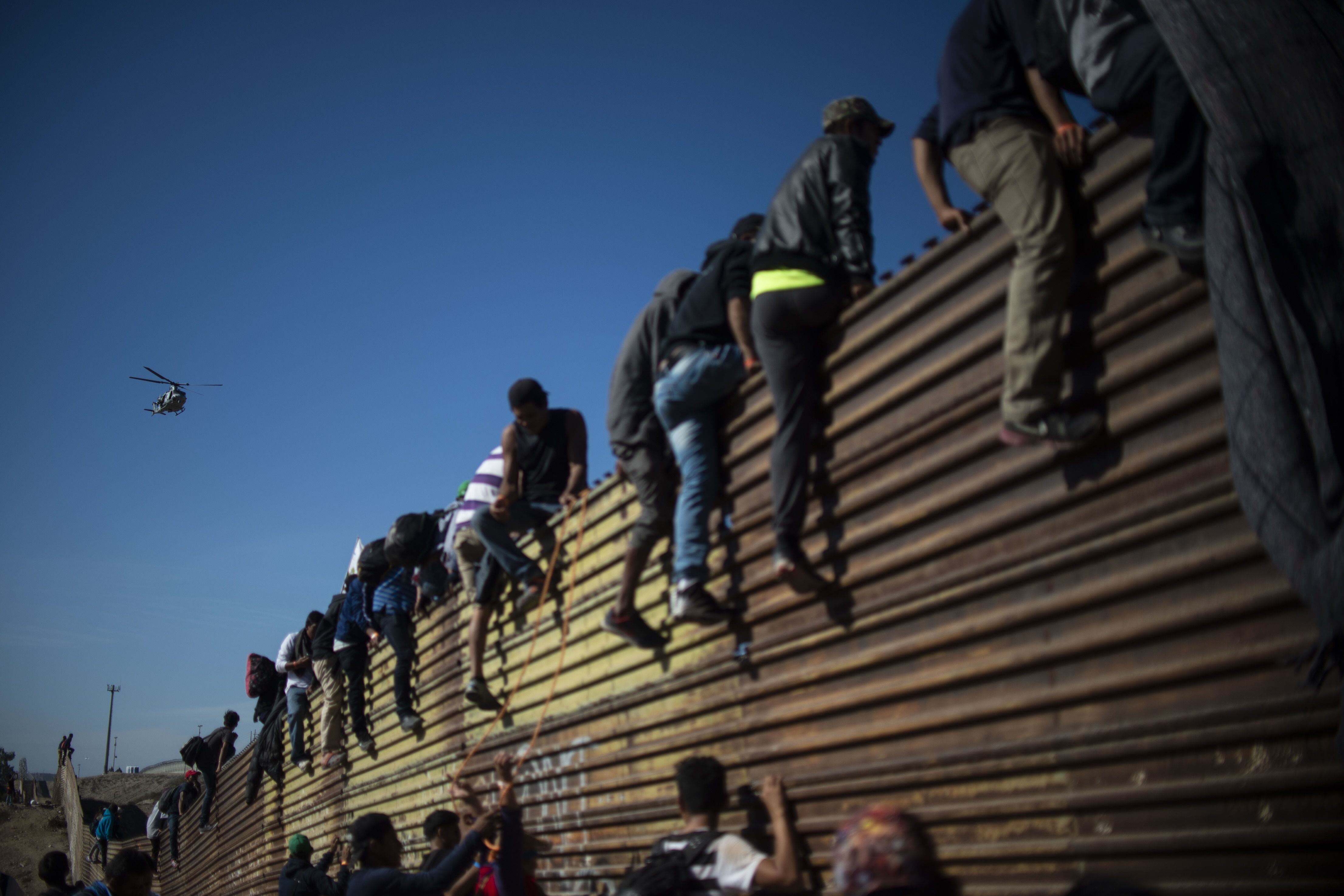 Un grupo de migrantes escaló una valla cerca del cruce fronterizo de Chaparral, entre México y Estados Unidos.