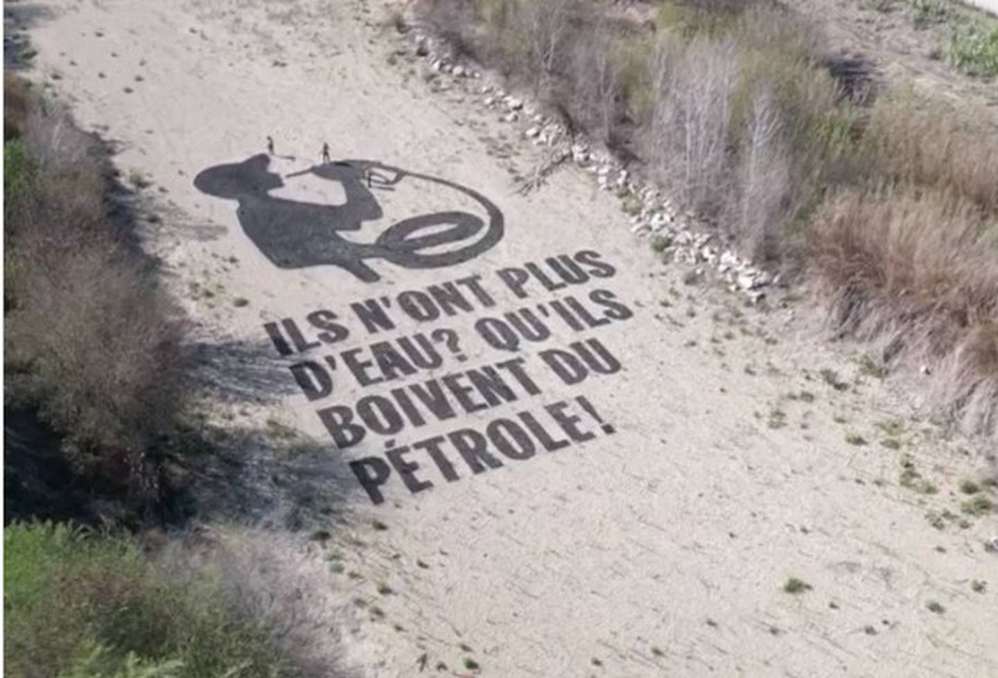 Activistas en Francia pintaron en el cauce seco del río Agly  "Si no hay agua, ¡que beban petróleo!" y culparon al gigante petrolero TotalEnergies de la crisis climática.