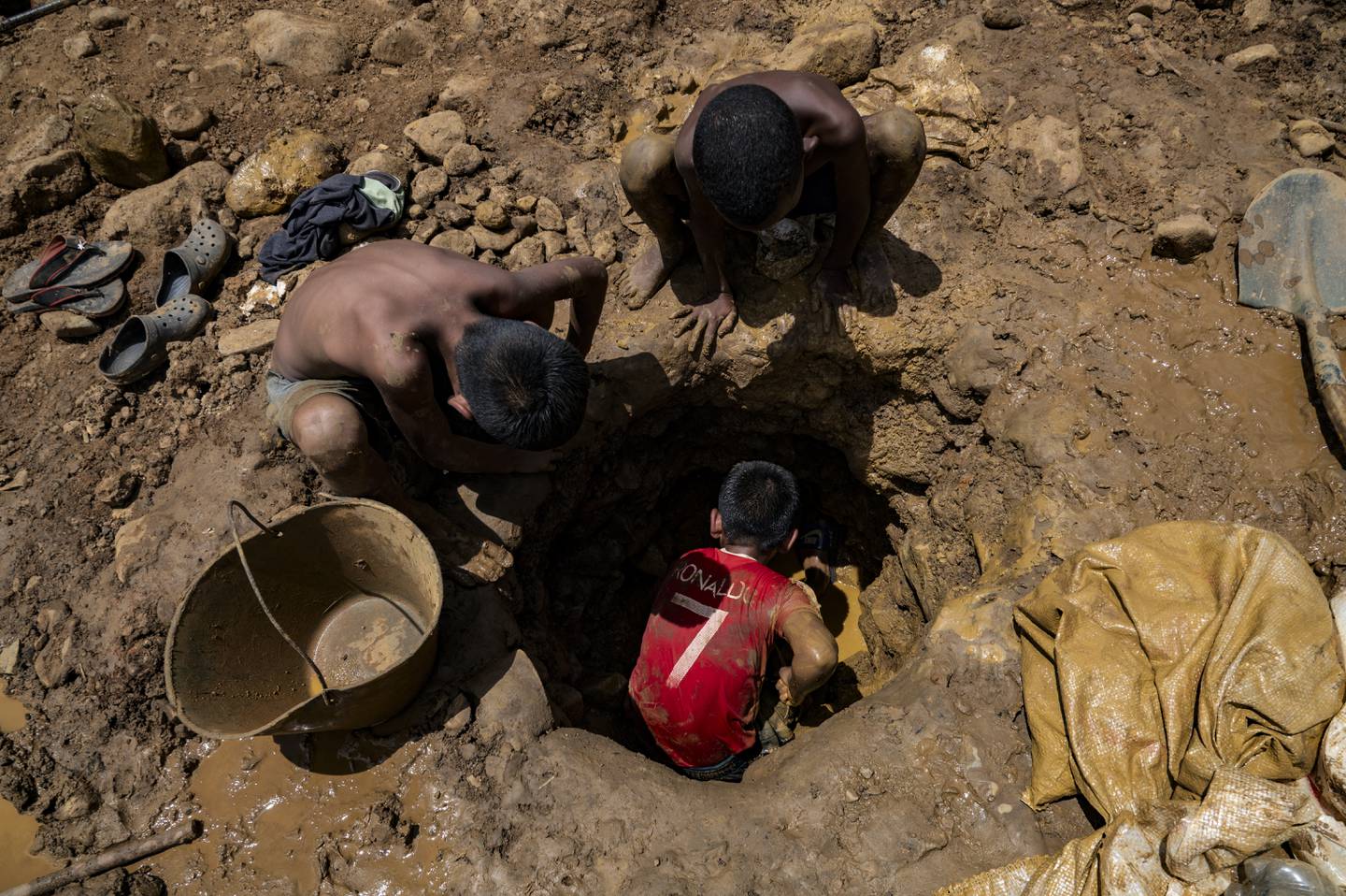 Niños mineros venezolanos trabajan excavando en una mina en busca de oro para luego venderlo en El Callao