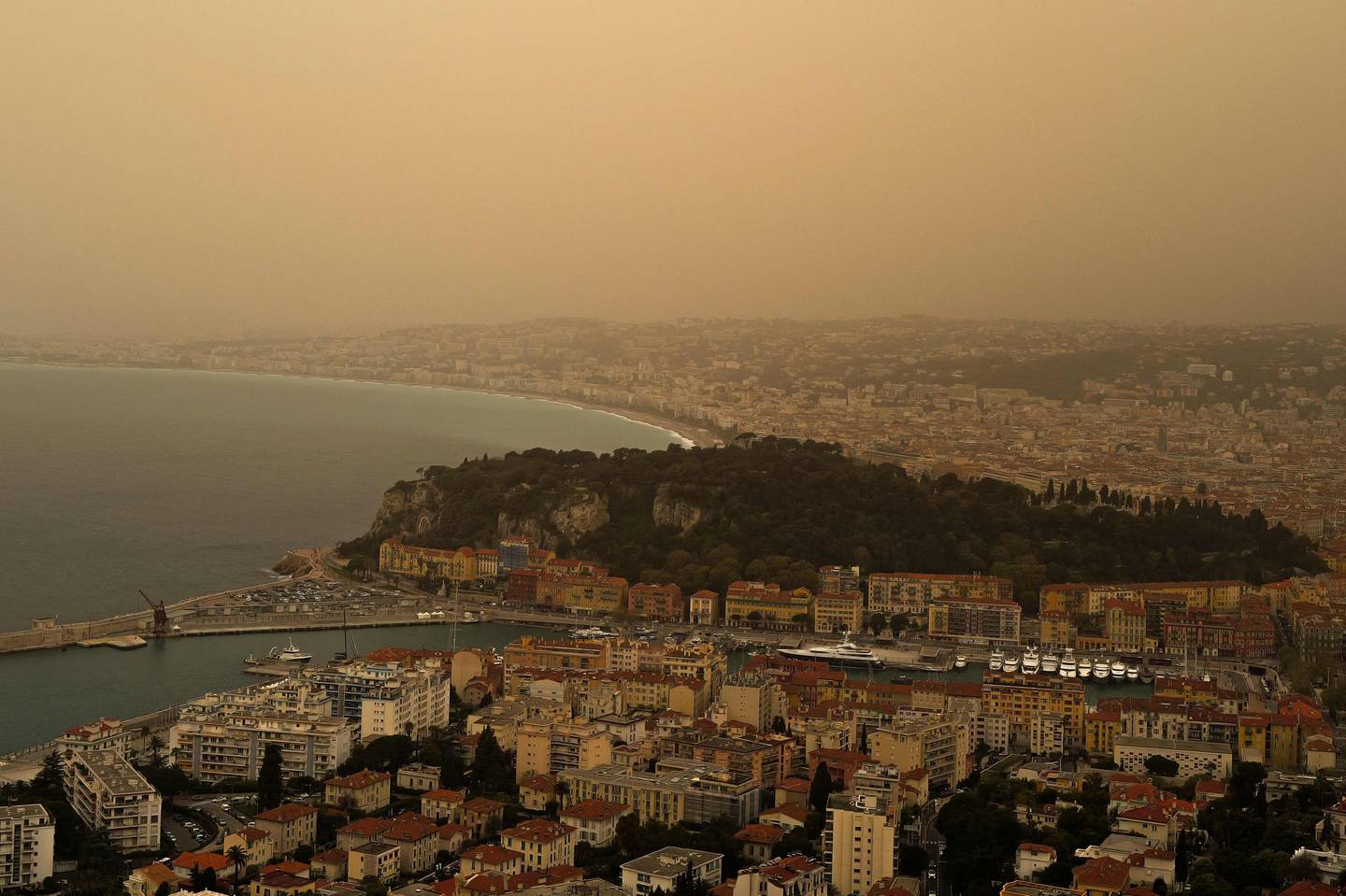 Esta fotografía tomada este sábado muestra un espeso polvo de arena arrastrado desde el Sahara dando al cielo una apariencia amarillenta sobre la ciudad de Niza, en la Riviera francesa, en el sur de Francia. Este color se debe a la arena arrastrada desde el desierto del Sahara y el norte de África. (Foto de Valery HACHE / AFP)