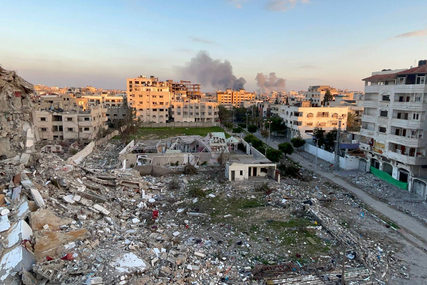 Una fotografía tomada en la ciudad de Gaza muestra escombros de edificios destruidos y humo ondeando al fondo durante el bombardeo israelí el 20 de febrero de 2024, en medio de continuas batallas entre Israel y el grupo militante palestino Hamás. (Foto de AFP)