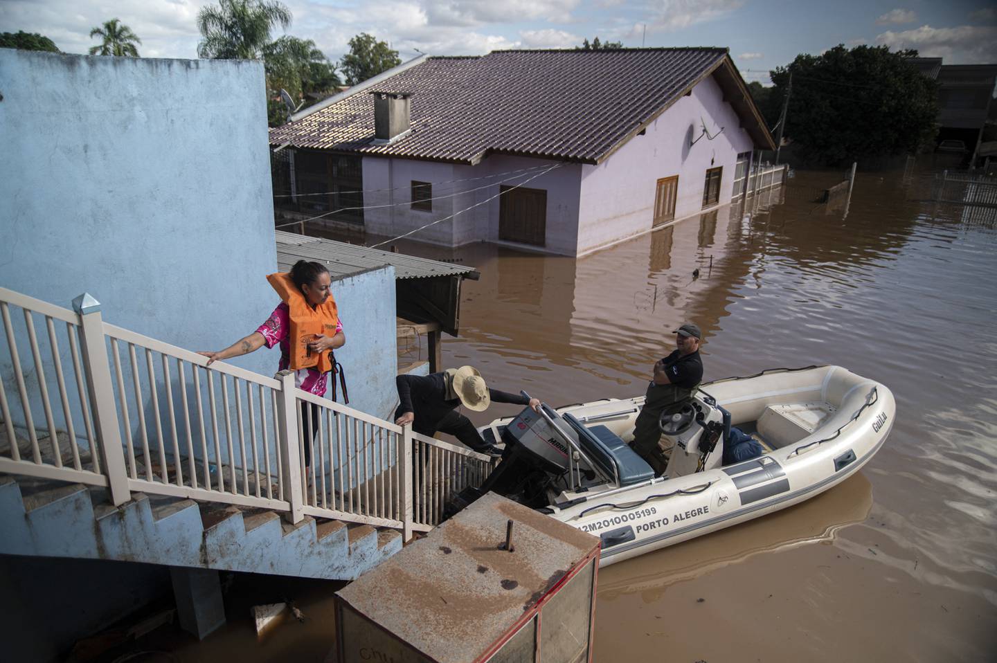 Katiane Mello (izq.) observa su vecindario antes de salir de su casa inundada en Eldorado do Sul, estado de Rio Grande do Sul, Brasil, el 9 de mayo de 2024. (Foto de Carlos FABAL/AFP)